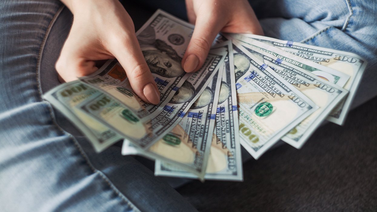 Person fanning out $100 bills