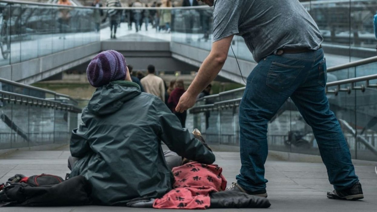 Person giving money to unhoused individual