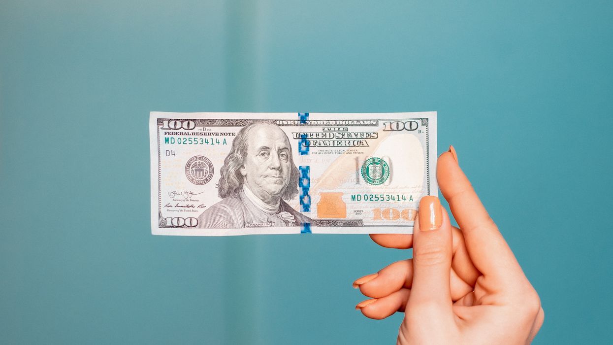 Person holding a $100 bill