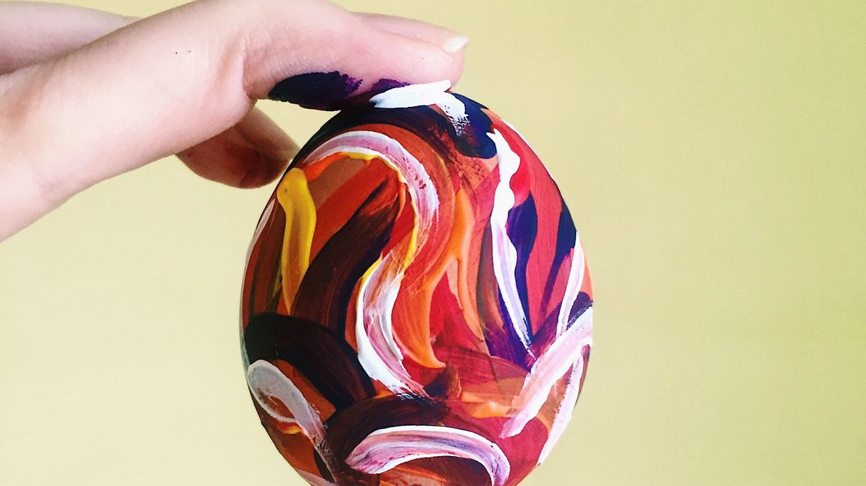 person holding a brightly painted egg