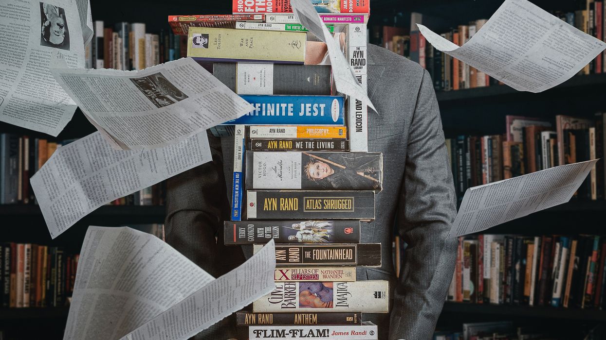 Person holding large stack of books