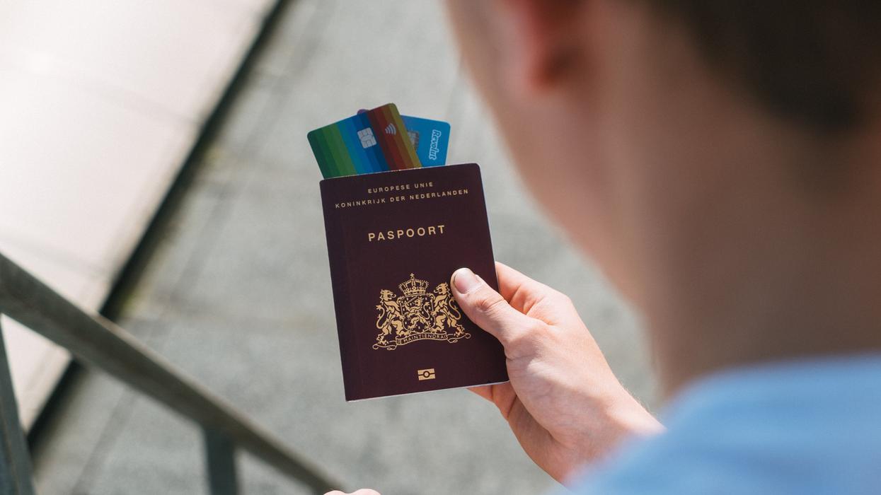 Person holding passport and credit cards