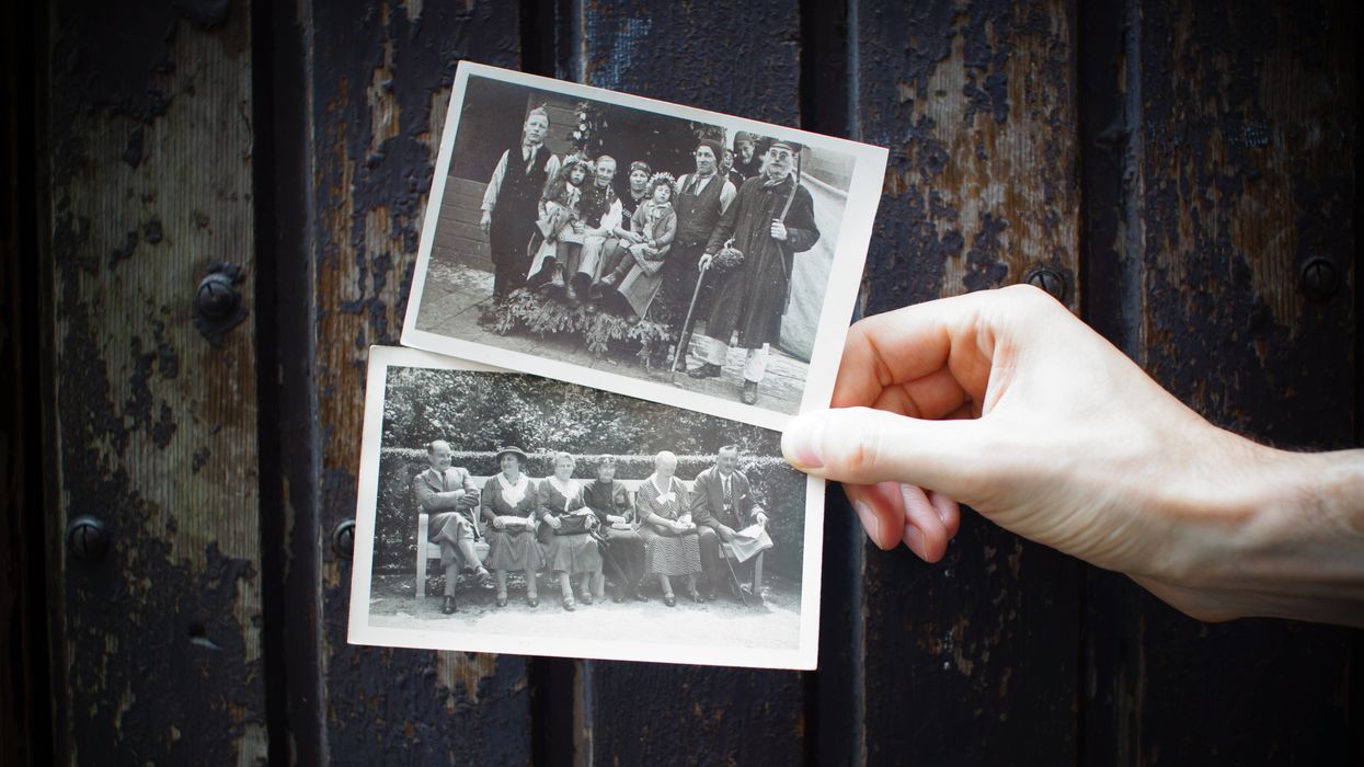 Person holding two vintage photographs of family portraits
