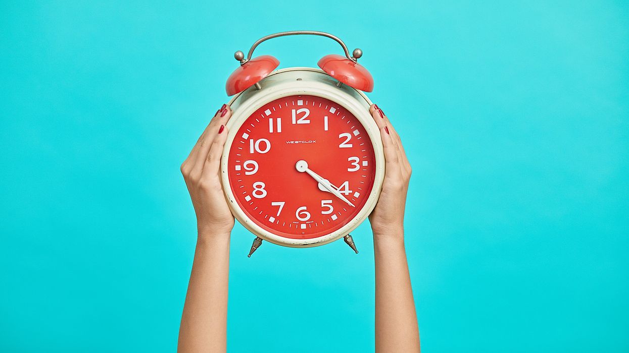 Person holding up an alarm clock