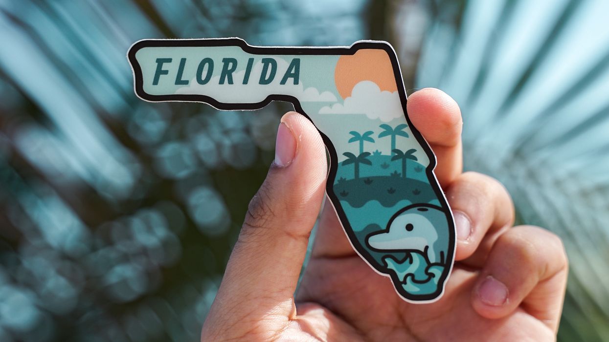 Person holding up magnet of Florida