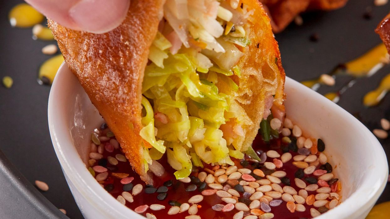 person holding white ceramic bowl with brown food