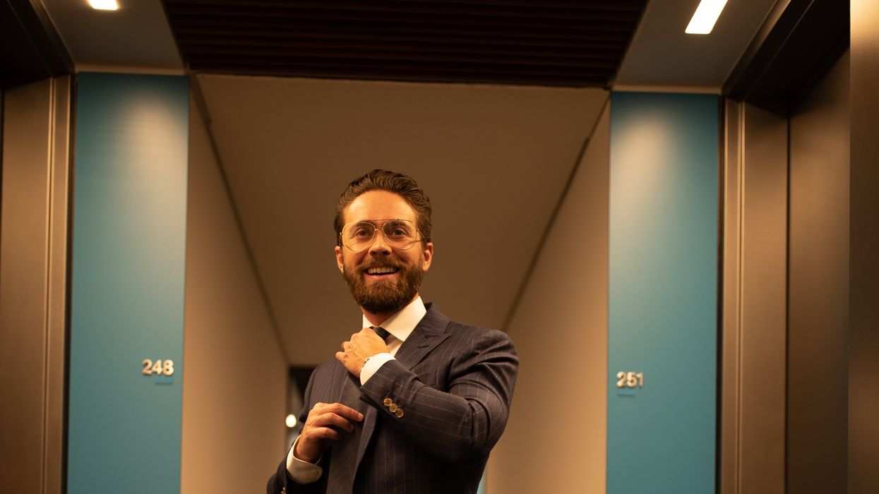 person in pinstriped suit jacket straightening their tie