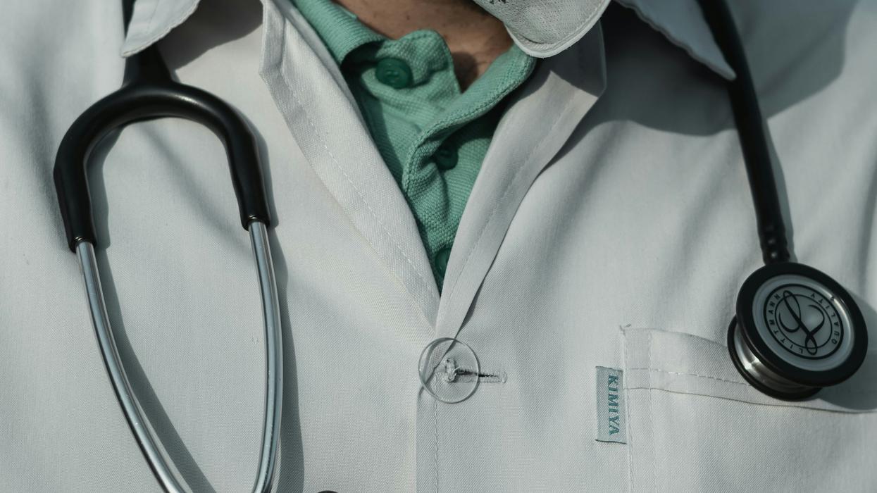 person in white with black stethoscope