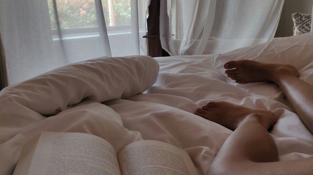 person lying on bed reading book