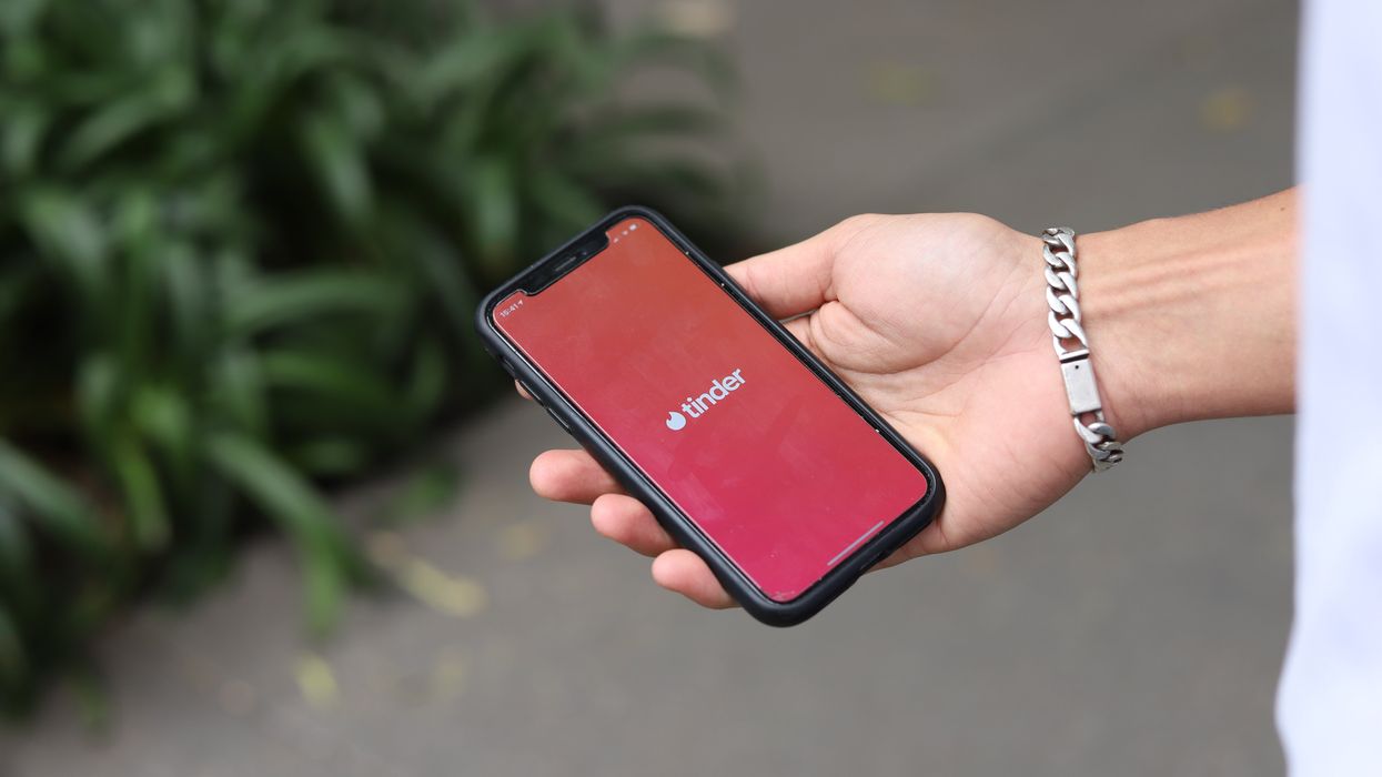 Person opening the Tinder app on their smartphone
