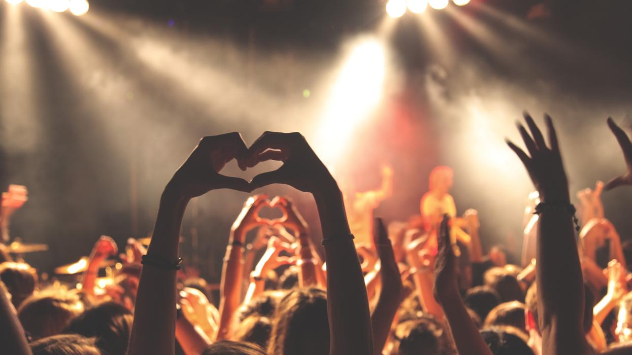 person performing heart hand gesture in crowd