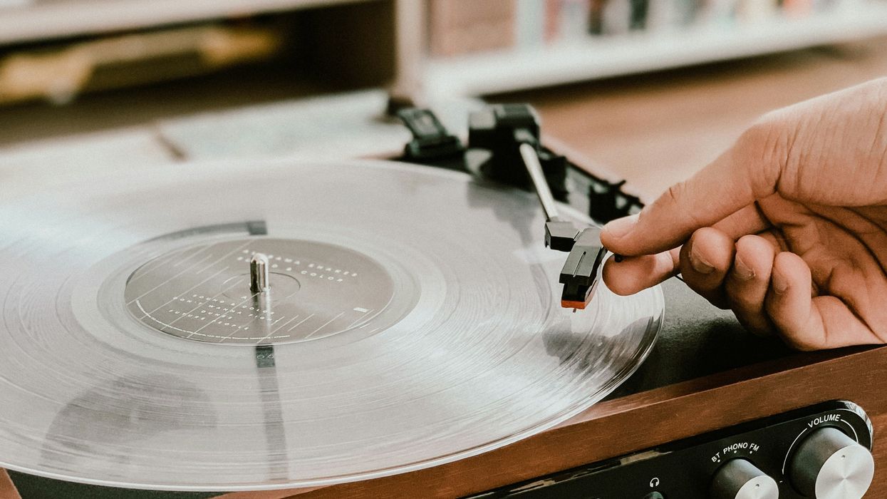 Person placing a needle onto spinning record