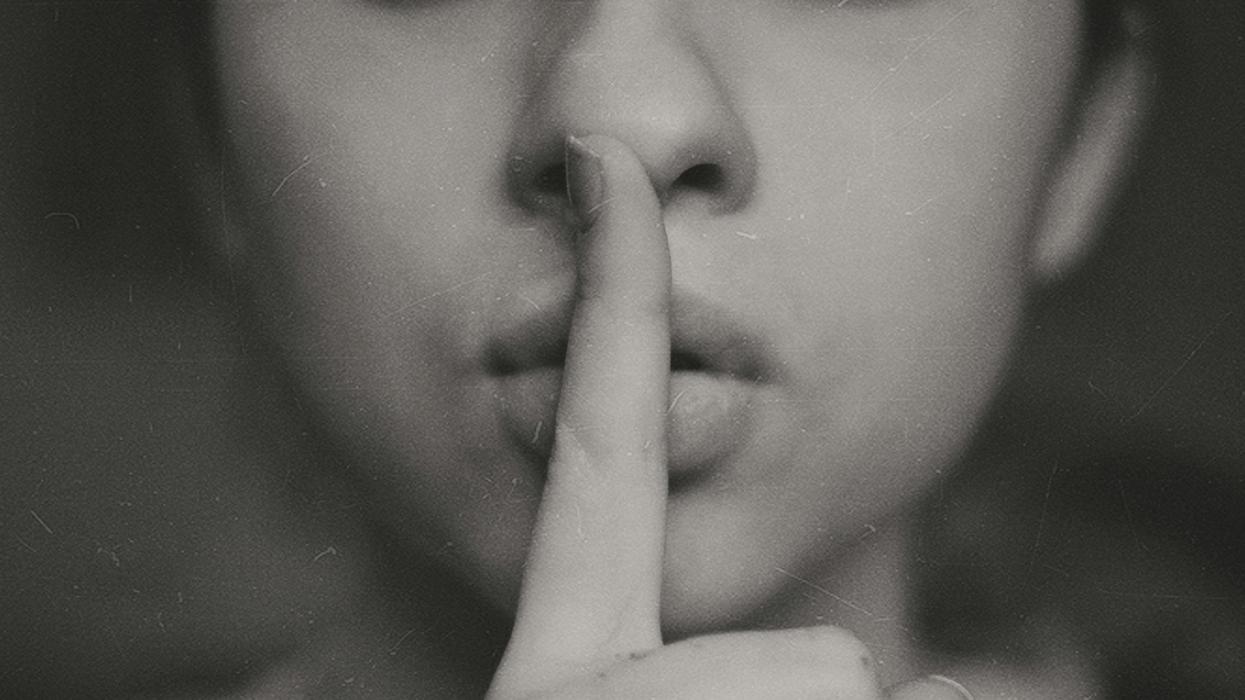Person saying, 'Shh!' with finger pressed to their lips