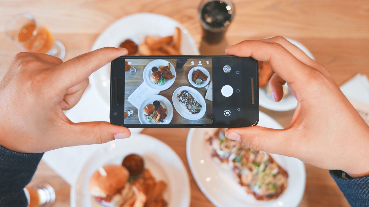 Person taking a picture of their food with their phone.