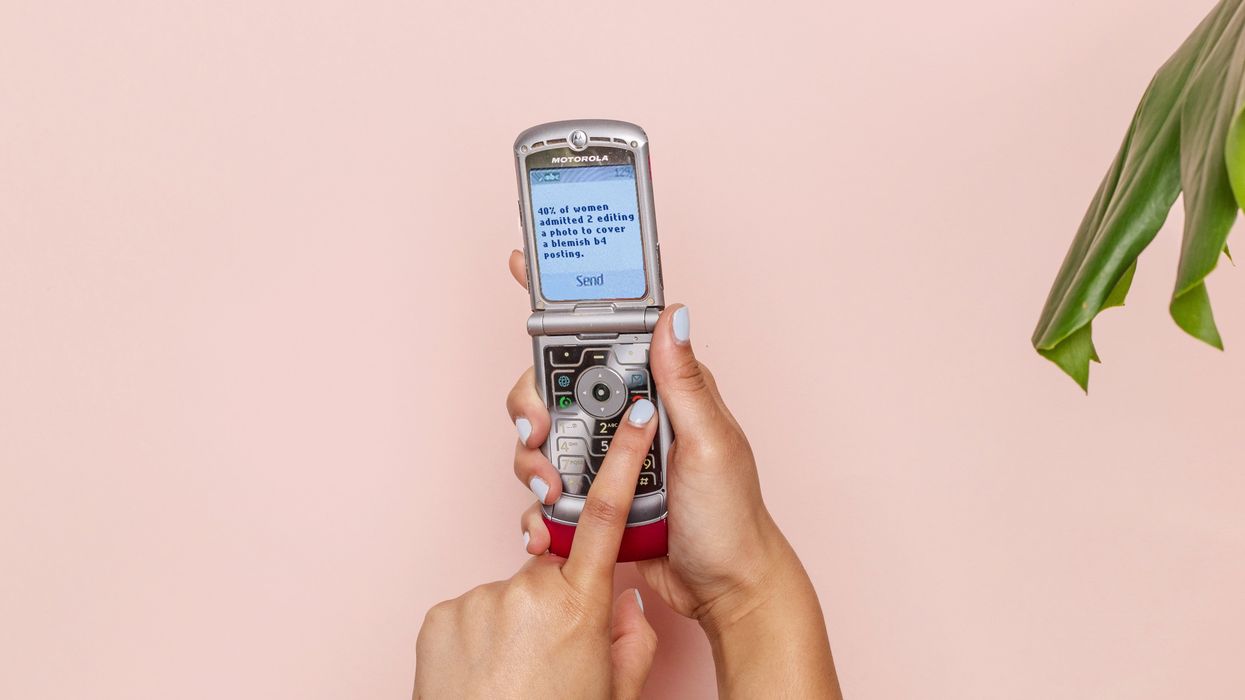 Person texting with silver flip phone