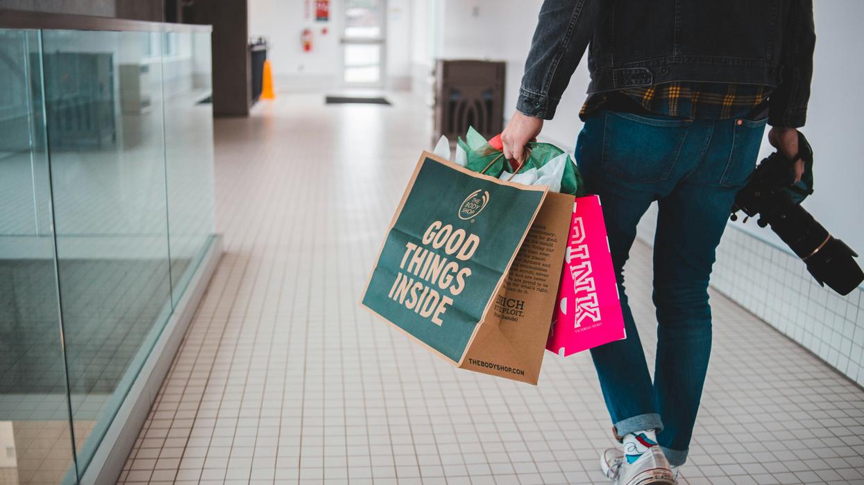 person walking in shopping mall with purchases