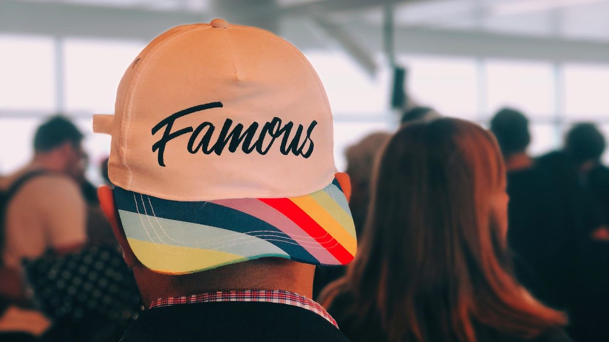 Person wearing a cap backwards that reads, 'Famous'