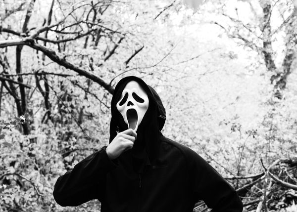 Person wearing a "Scream" mask from the slasher movie