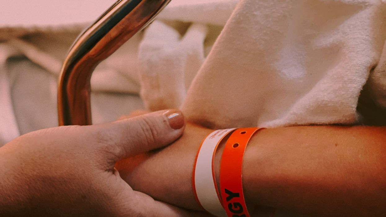 person wearing orange and white silicone band
