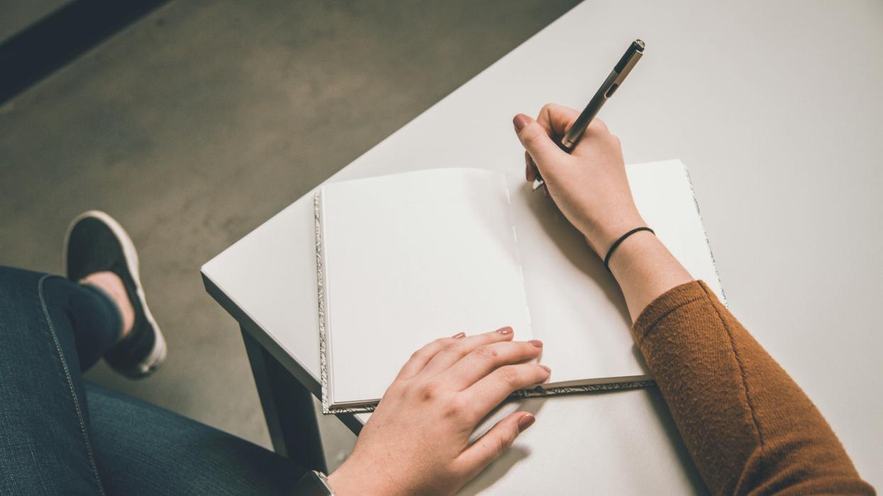 Person writing on notepad