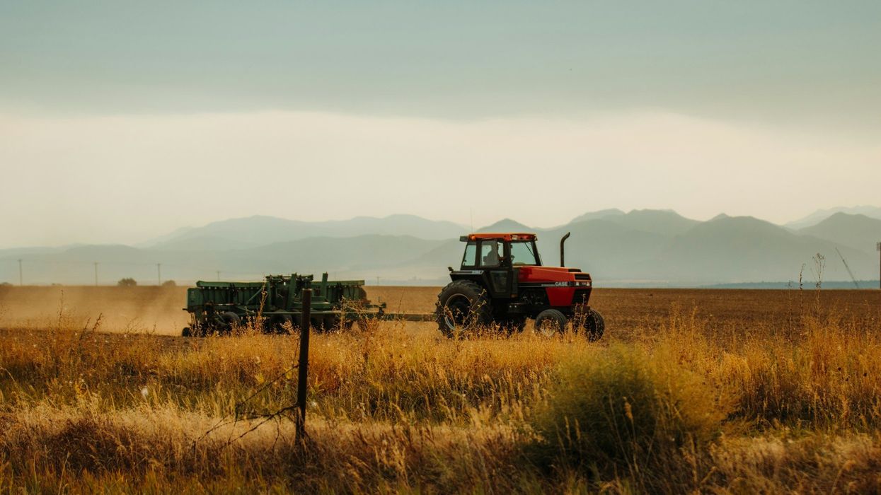 Photo of a tractor pulling a rig on an open prairie.