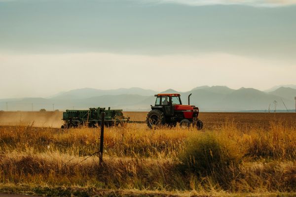 Photo of a tractor pulling a rig on an open prairie.