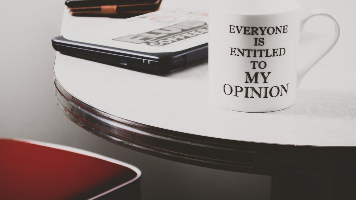 Photo of an iphone, laptop and mug that says "Everyone Is Entitled To My Opinion"