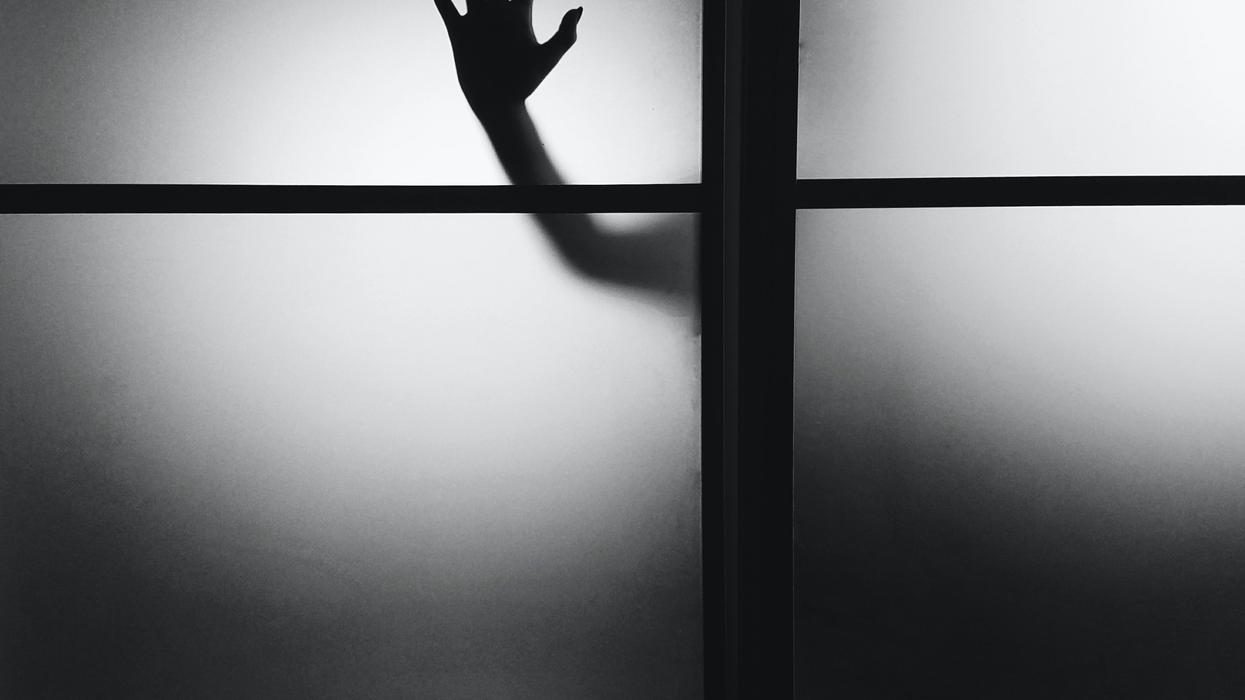 photo of person's hand on wall