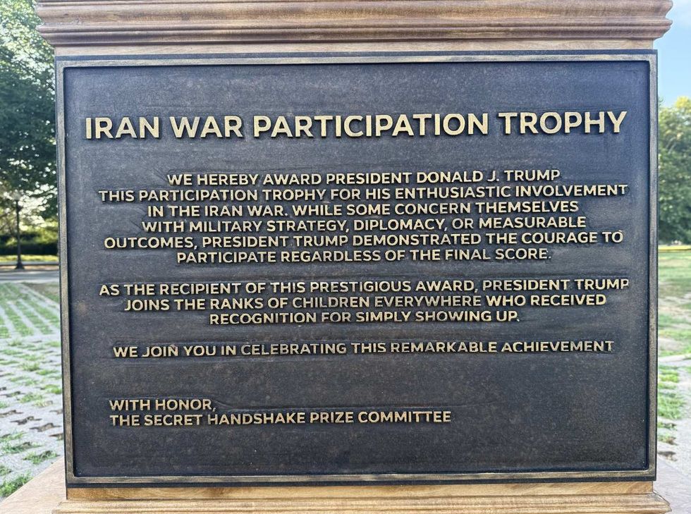 Plaque beneath "Iran War Participation Trophy" installation