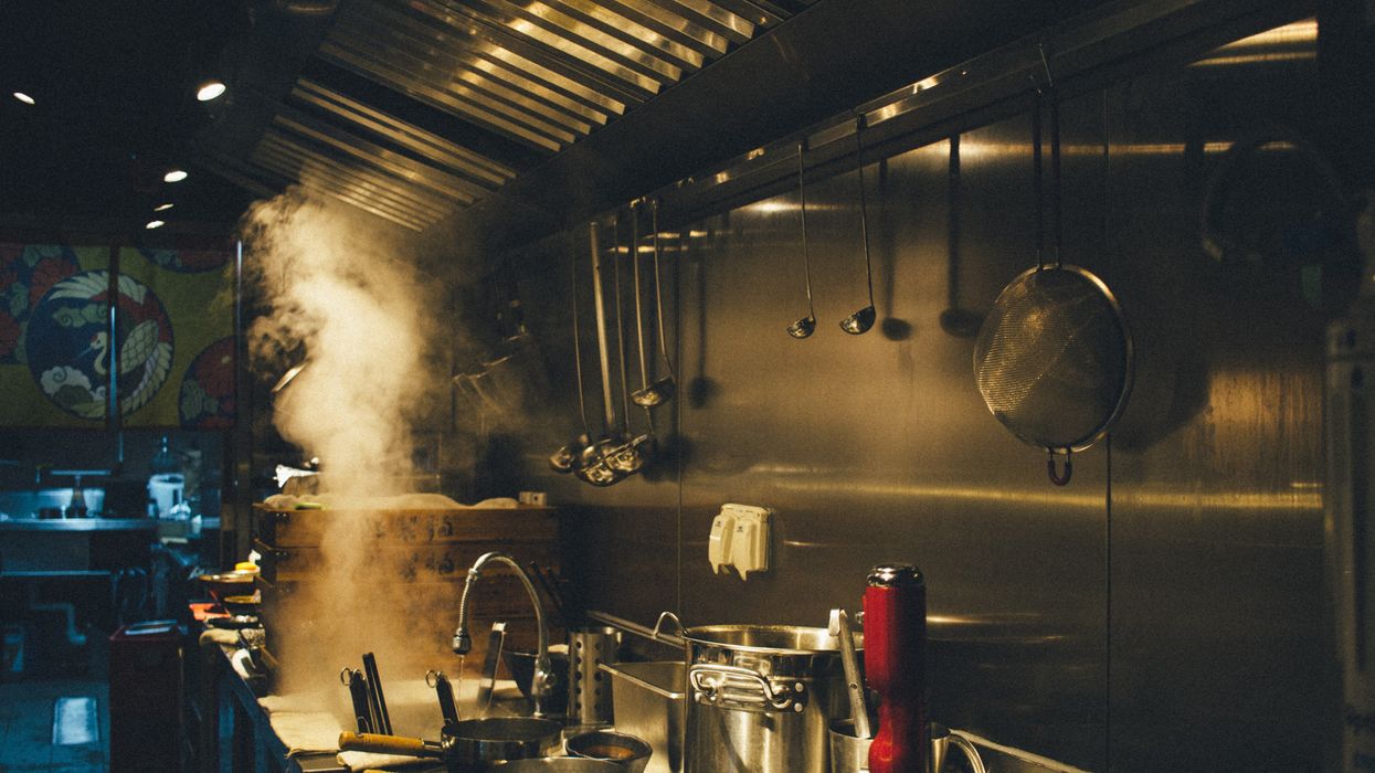 Pots and pans on a stove in a restaurant kitchen.