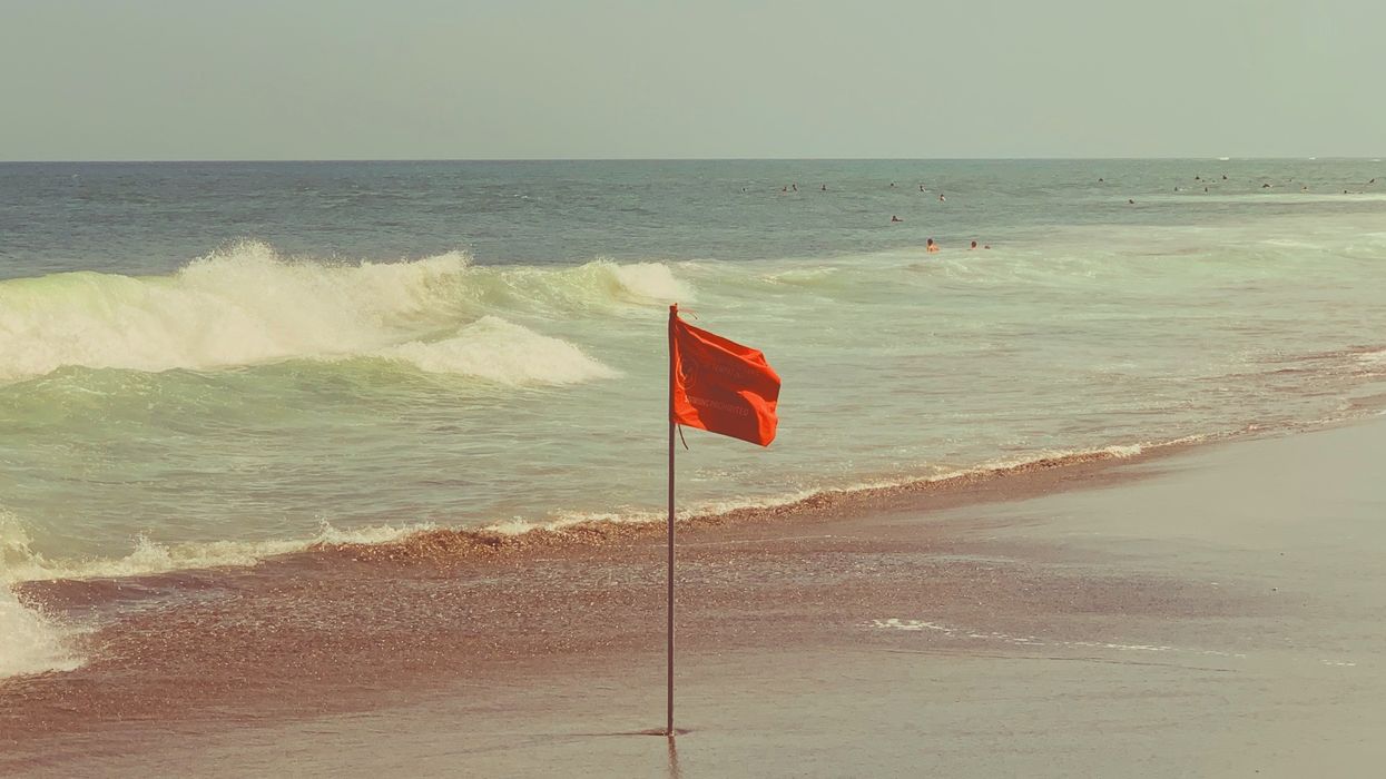 Red flag planted on a beach