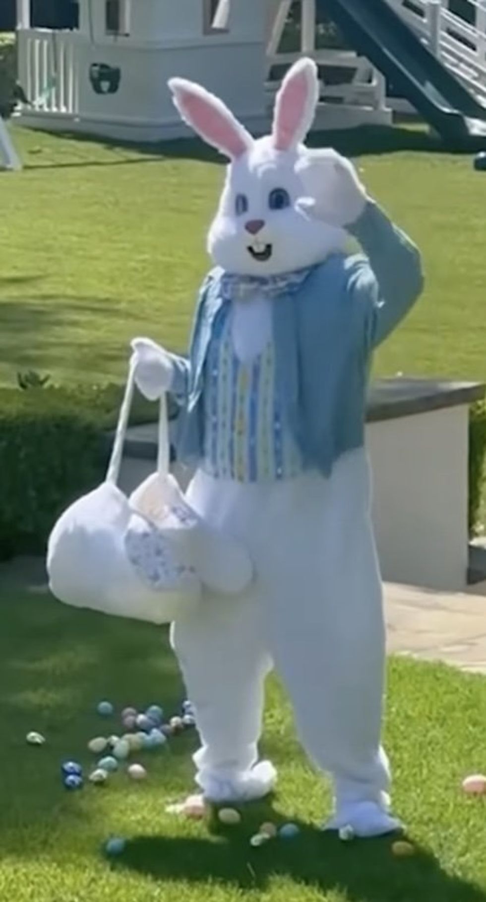 Rob Lowe's Easter Bunny costume with a basket, surrounded by colorful eggs on the grass.