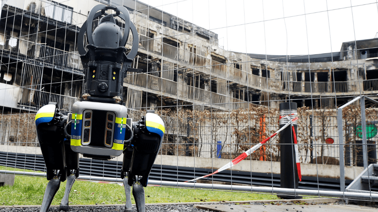 Robot with police stripes standing in an urban background
