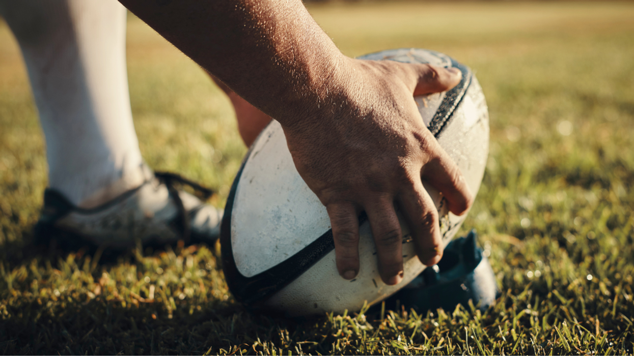 Rugby player preparing for a kick on the field