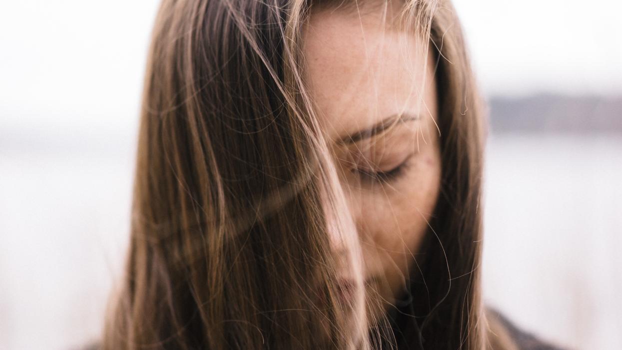 Sad woman with hair blowing in front of her face