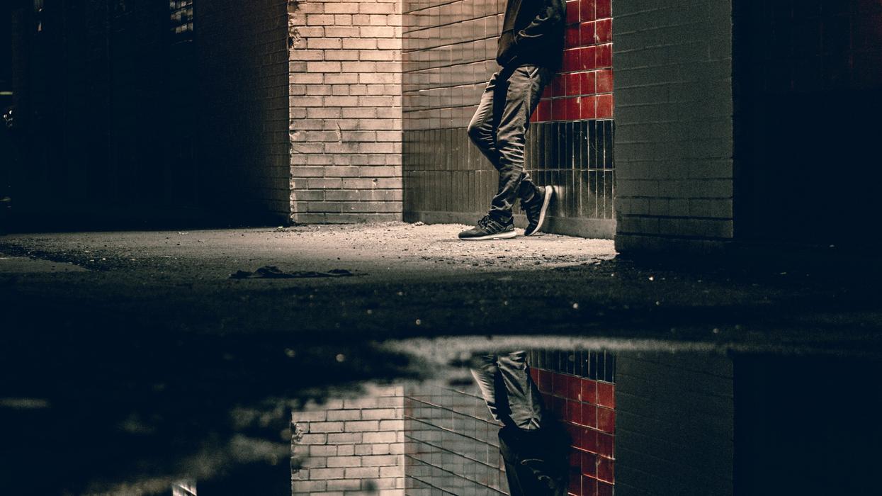 Sad young man in alleyway