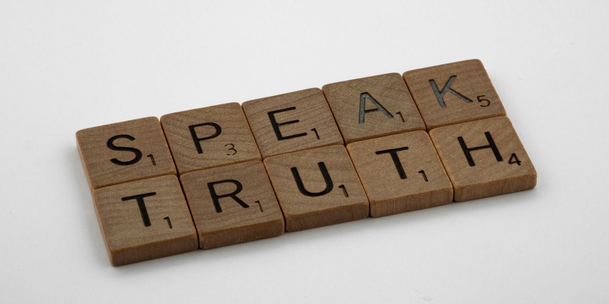 Scrabble tiles spelling "speak, truth".