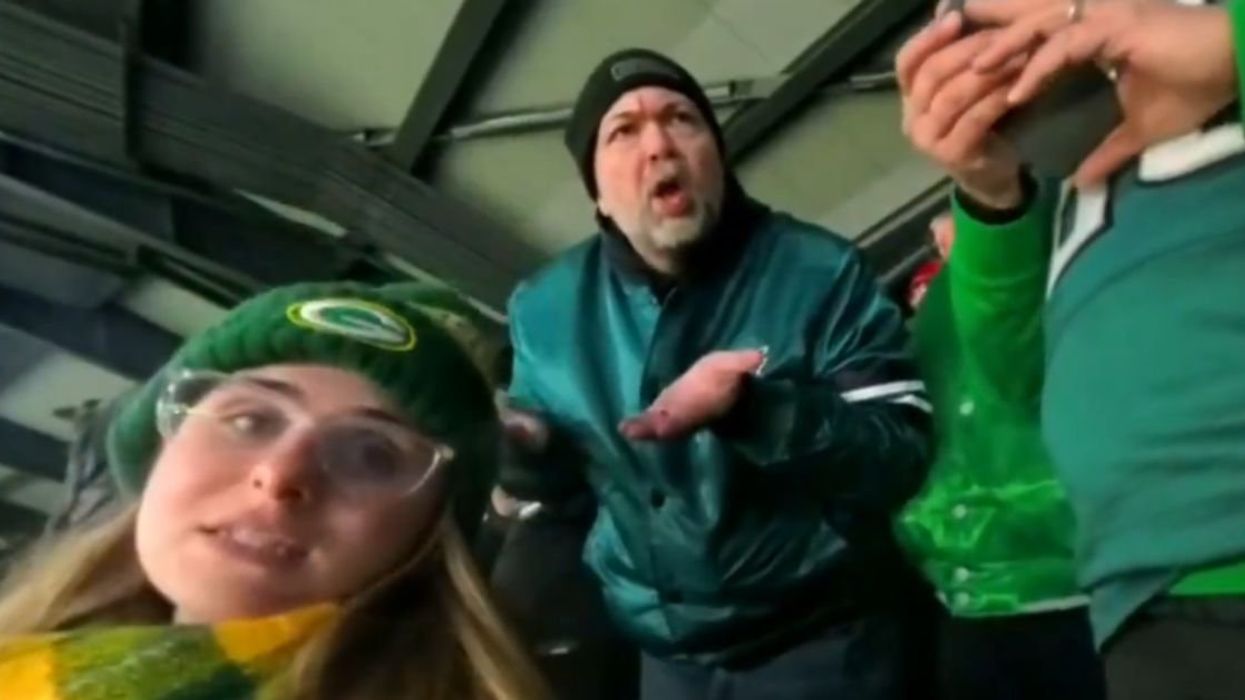 Screenshot of angry Philadelphia Eagles fan behind female Green Bay Packers fan
