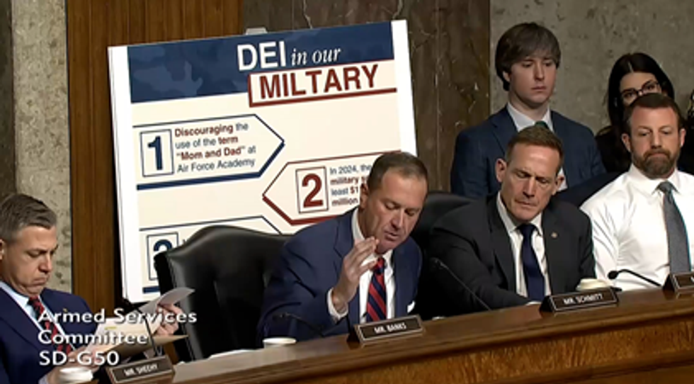 Screenshot of misspelled "miltary" sign behind Eric Schmitt
