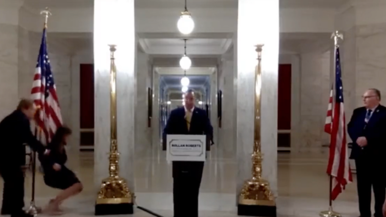 Screenshot of Rollan Roberts speaking as his wife Rebecca faints