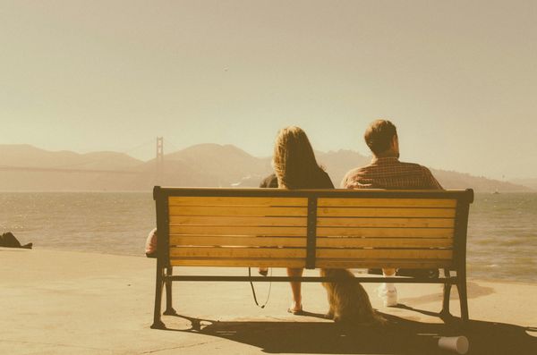 Seemingly distant couple sitting on park bench