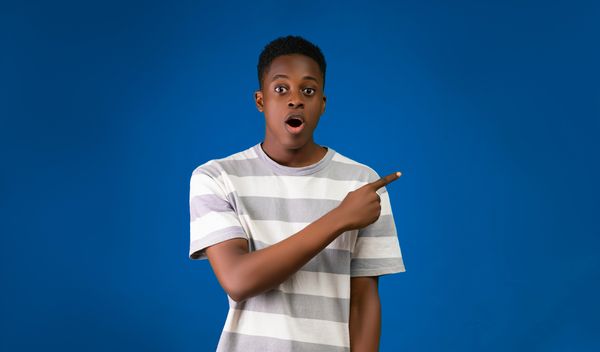 shocked young man pointing to his left