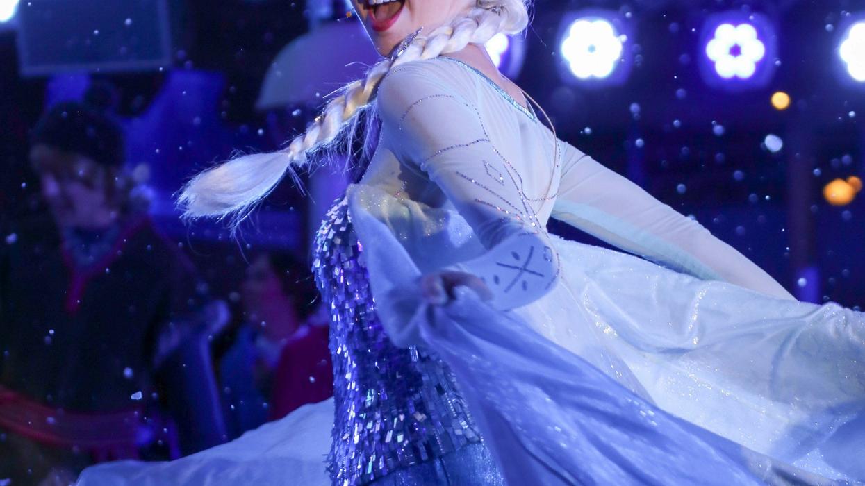 Shot of a live action Elsa from "Frozen" dancing and singing with her eyes closed.