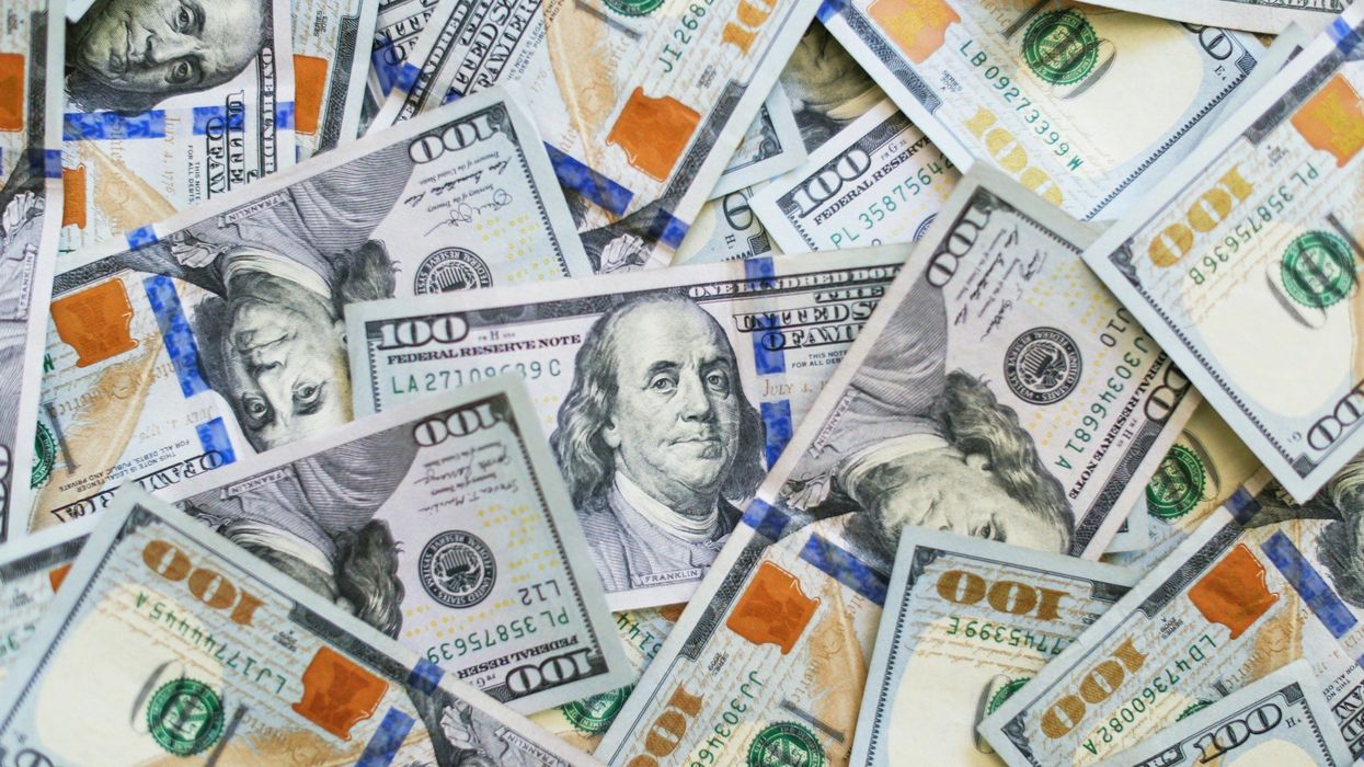 Shot of a pile of scattered one hundred dollar bills.