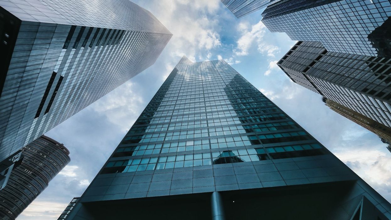 Shot of several skyscrapers pointing into a blue sky, from the ground up
