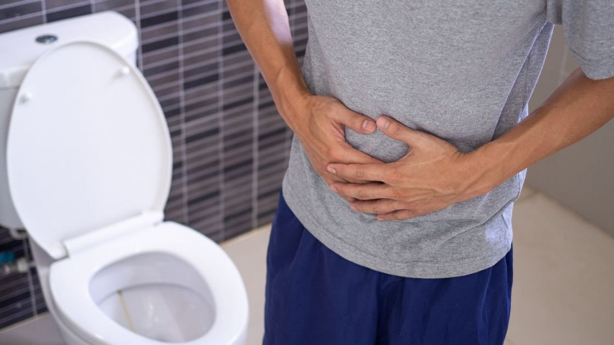 Sick person in bathroom holding their stomach