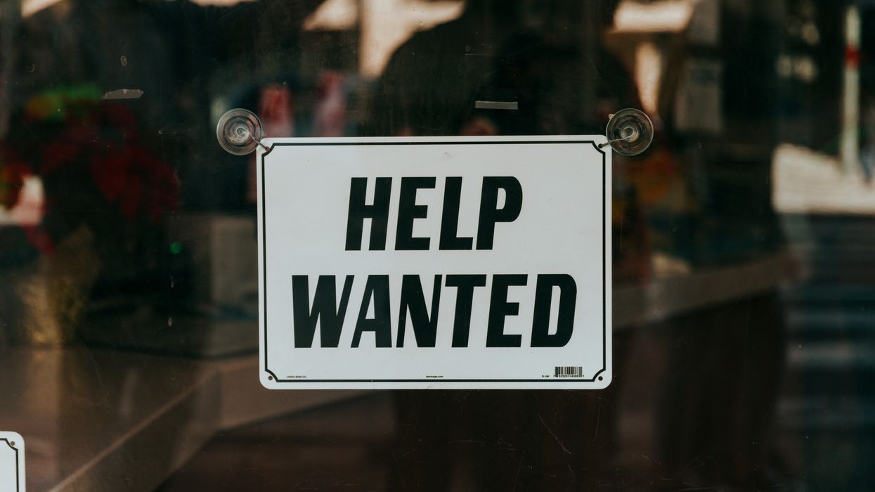 sign that says "help wanted" on a glass door