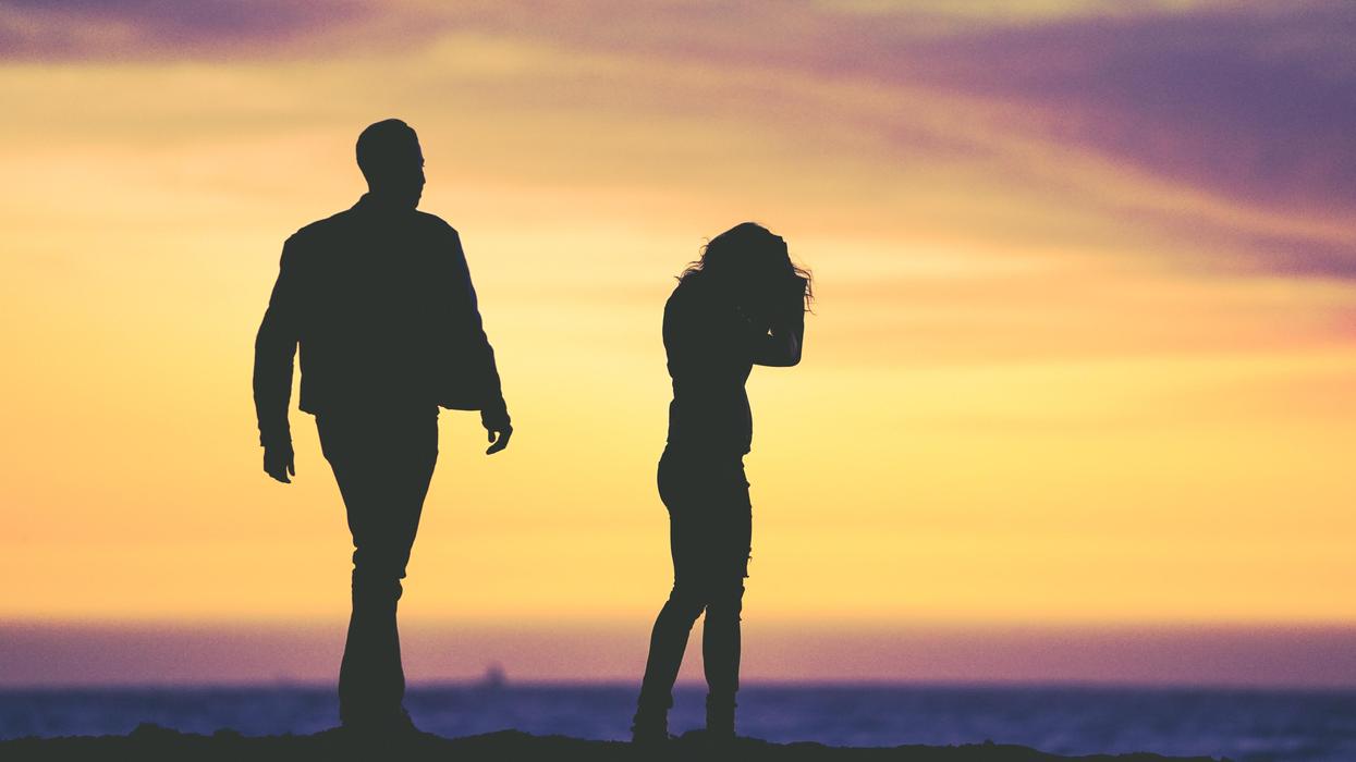 silhouette of man and woman under yellow sky