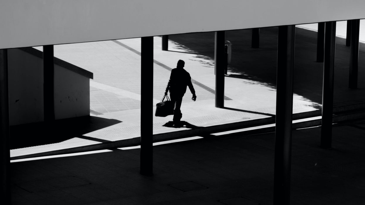 Silhouette of man leaving an office carrying a briefcase