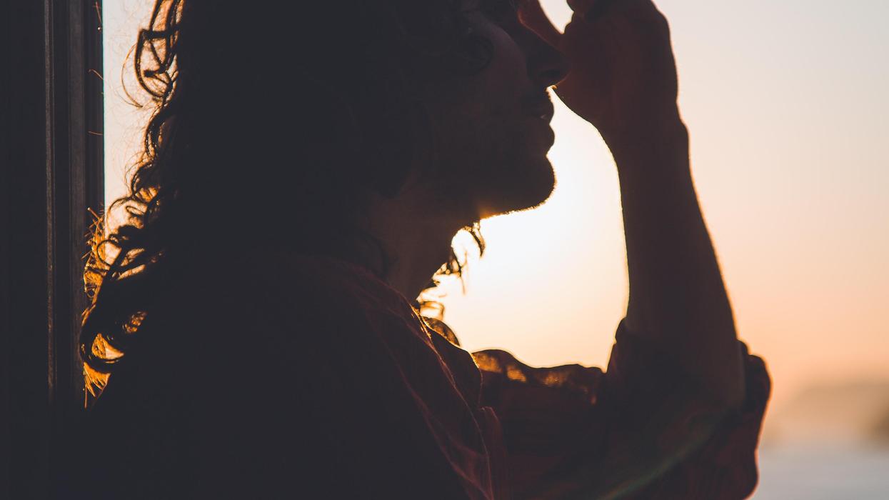 Silhouette of woman rubbing head